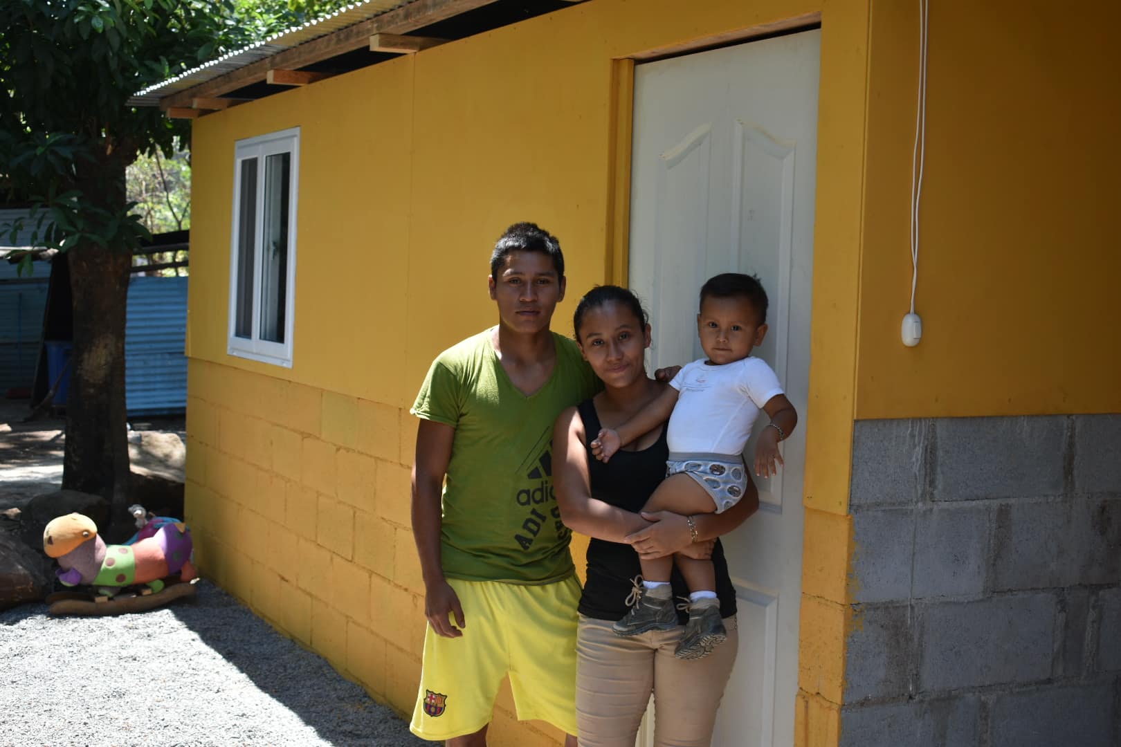 Guatemalan family stand in front of new home